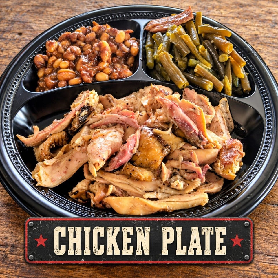 Black platter of seasoned chicken, baked beans, and green beans on a wooden table, labeled Chicken Plate.