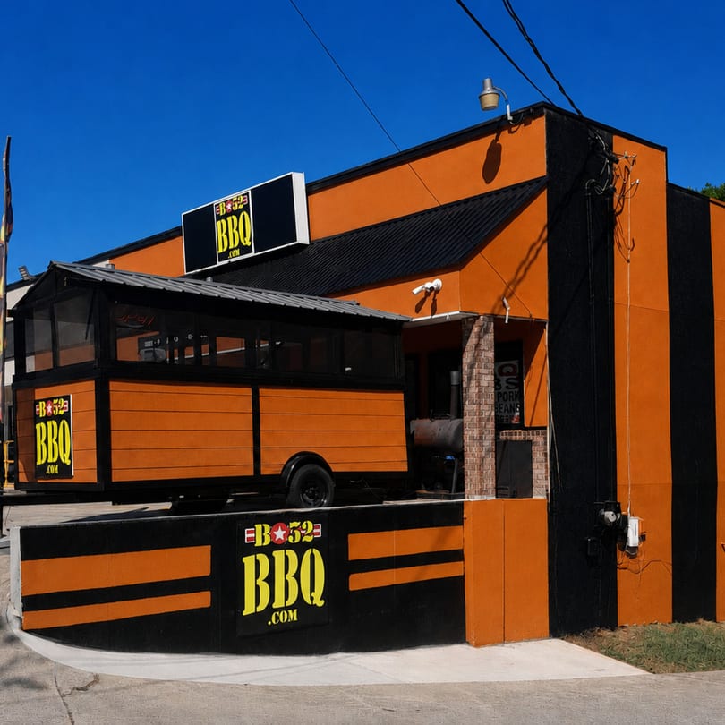 B-52 BBQ restaurant exterior, orange and black striped building with a matching food trailer.