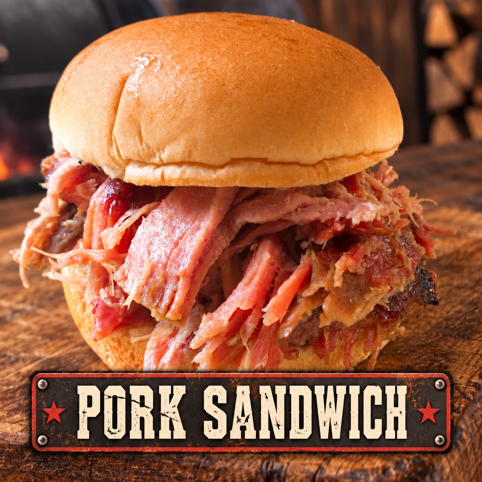 Close-up of a pork sandwich piled with sliced pork, crispy bacon, sauce, and vegetables on a wooden table.